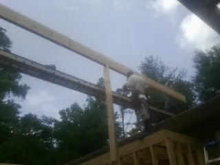 Carpenter setting a ridge beam over a new addition frame — Ice Dam Removal by Roofing Brothers in Fishers