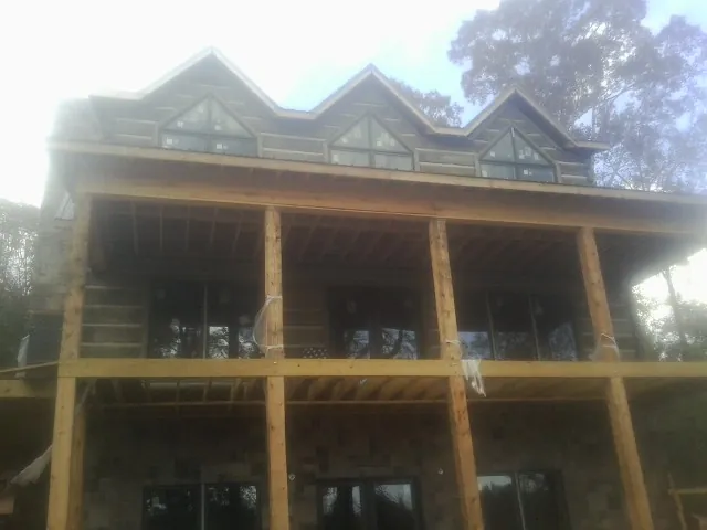 Dormers and porch framing on a large log home under construction — Roof Coating work by our crew in Fishers